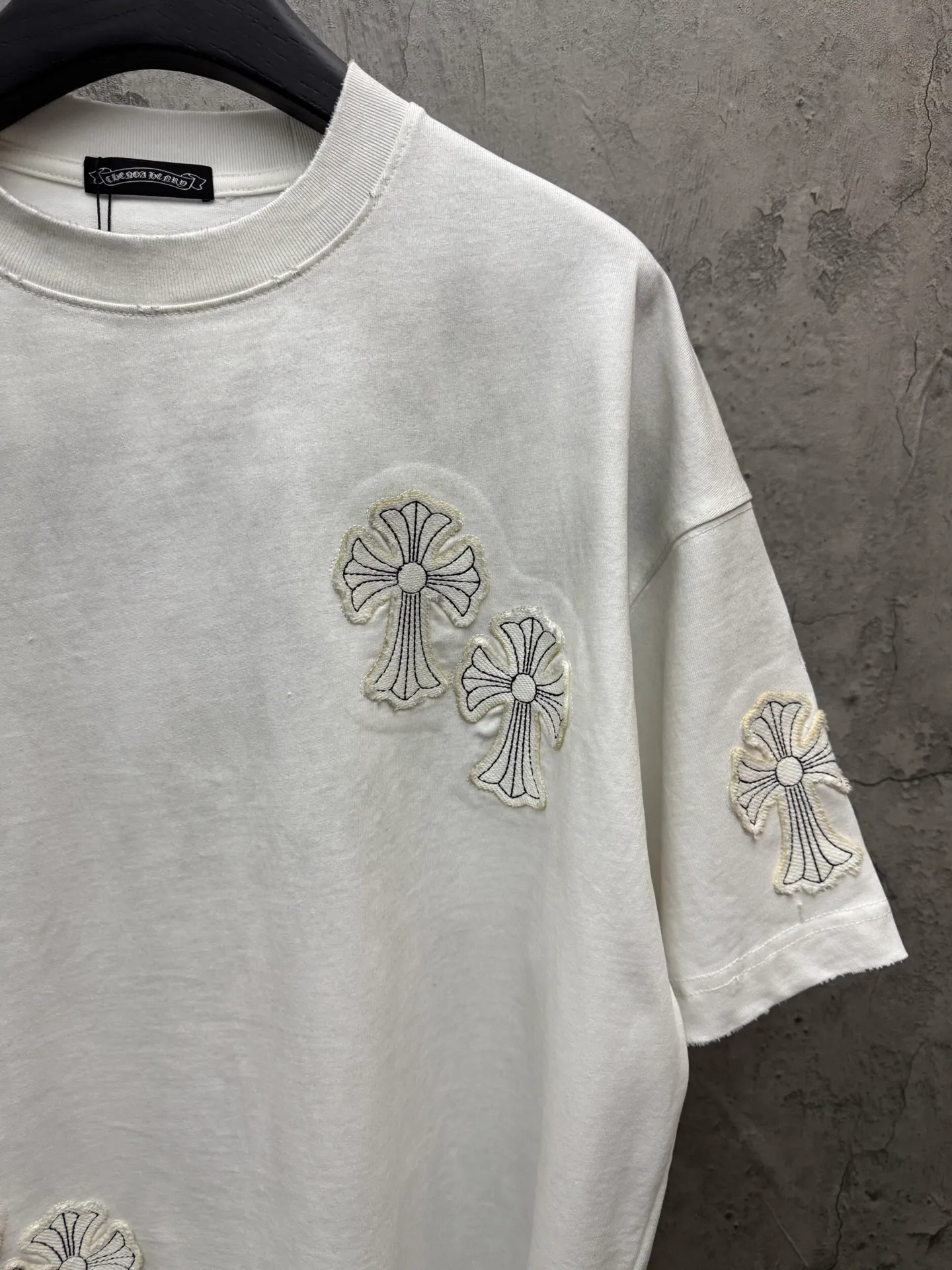 P240 top version, real shot without P, ​​different from market currency) 𝗖𝗵𝗿𝗼𝗺𝗲 𝗛𝗲𝗮𝗿𝘁𝘀/Croxin 2026 spring new original single counter American washed patch embroidered couple short sleeves 👑The highest version! Customized fabric 320 grams, washed and fried, a hot-selling model at the counter, very comfortable to wear. Accessories: original molded and authenticated collar label➕100% silk wash label. Genuine purchase-grade original hangtag➕matching hanging rope➕3D hanging beads➕original packaging bag. Craftsmanship: The original version has consistent wiring! The highest version of the armhole matching technique! Color: Black White Size: S M L XL Style No.: 5206